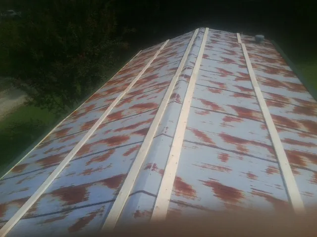 Rusted metal roof panels with new wood purlins before replacement — Storm Damage Roof Repair in Henderson by Roofing Brothers